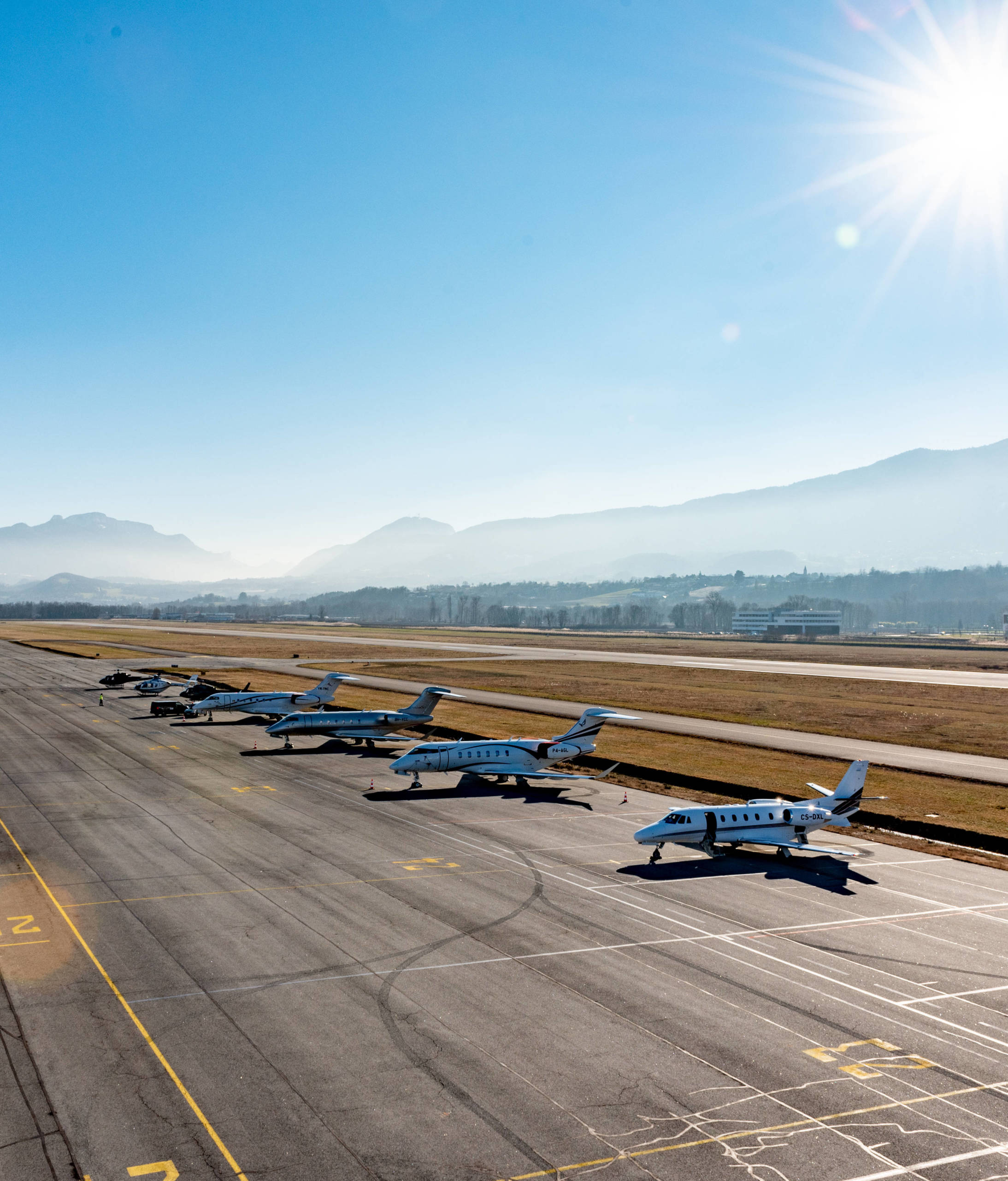 jet privé sur tarmac à Chambéry avec montagnes en fond dont le mont granier