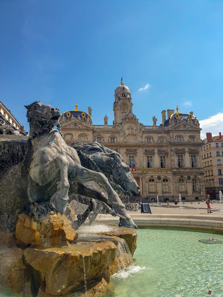 Il s'agit de la mythique place de Lyon, la place des terreaux. Sur la photo, il fait jour, on peut voir la statue du monument ainsi qu'une fontaine 