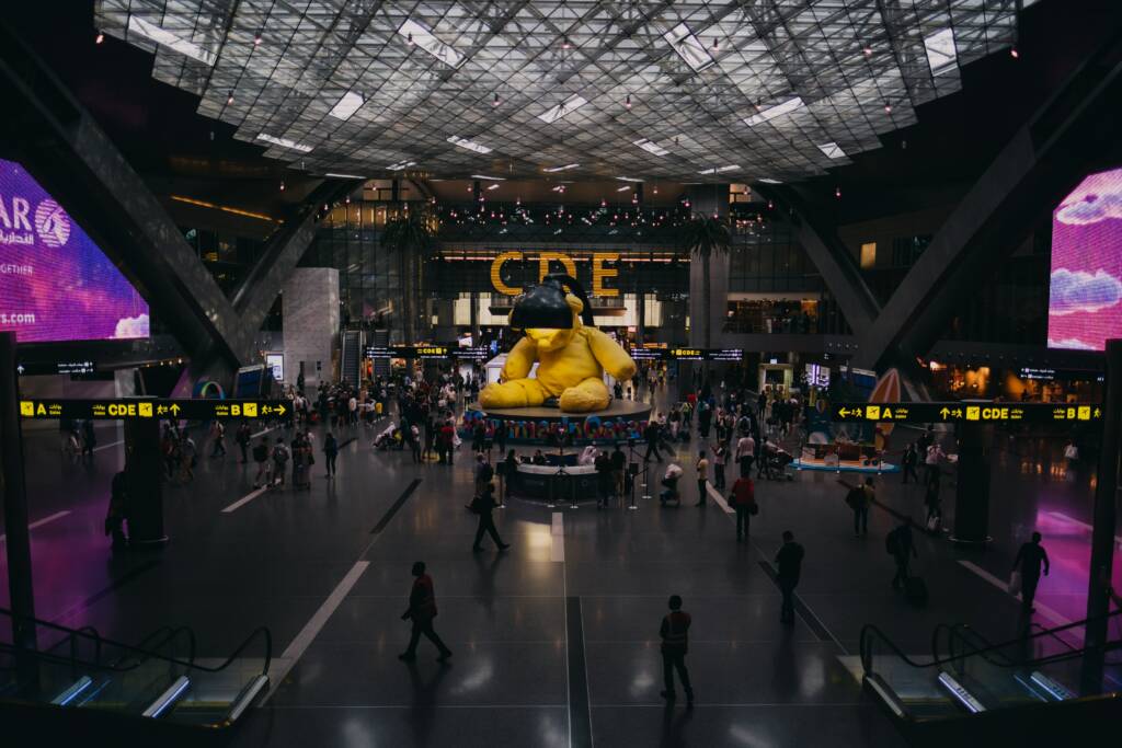 Aéroport Hamad International Airport. Il s'agit de l'aéroport international de Doha, on peut voir les portes d'embarquement ainsi que le hall principal de l'aéroport. On peut apercevoir un immense nounours. 